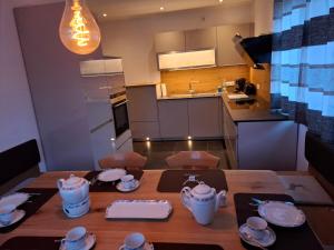 a kitchen with a wooden table with plates and cups at Chalet Ausweger - Strobl am Wolfgangsee in Strobl