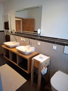 a bathroom with two sinks and a mirror and a toilet at Chalet Ausweger - Strobl am Wolfgangsee in Strobl +31 photos