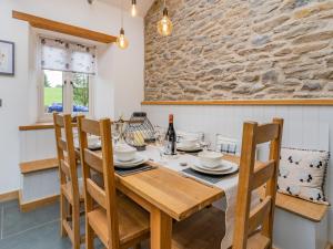 a dining room with a wooden table and chairs at Cwtch Ty Gwyn in Llandeilo