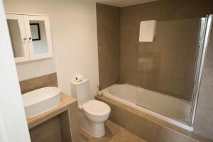 ein Badezimmer mit Toilette, Waschbecken und Dusche in der Unterkunft The Blacksmiths - Luxury Cottage Country Views in Ludchurch + 19 Fotos