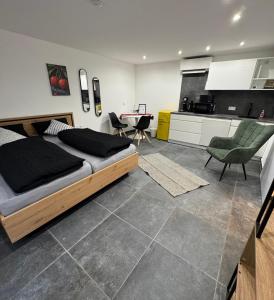 a bedroom with a large bed and a kitchen at Ferienwohnung Tee - Time - Lodge und Kirsch - Kiste in Momlingen