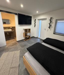 a bedroom with a bed and a flat screen tv at Ferienwohnung Tee - Time - Lodge und Kirsch - Kiste in Momlingen