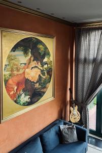 a painting on the wall of a living room with a couch at Alfa Hotel in Piraeus