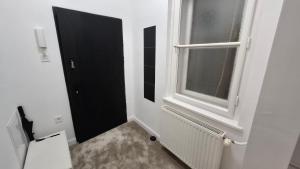 a bathroom with a black door and a window at Museum 4 Residence in Debrecen