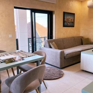 波德戈里察Apartments Aerodrom的带沙发、桌子和椅子的客厅