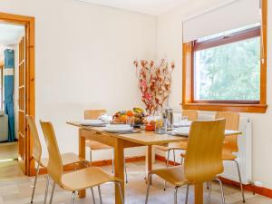 Un comedor con mesa y sillas de madera. en Glen View Of Enrick House, en Bearnock 25 fotos más