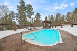 a swimming pool in the middle of a snow covered yard at 4 bedroom Cabin In Black Hills with Hot tub and Heated Pool in Lead