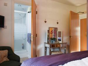 a bedroom with a bed and a mirror and a chair at 9 Howrah's Court in Keswick