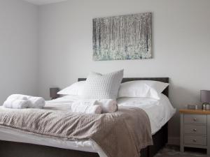 a bedroom with a white bed with towels on it at 4 Mote View-Uk37497 in Sandhead