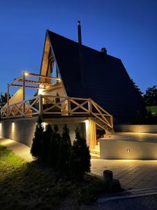 セルビアディヴツィバレにあるAzalea Chaletの夜の黒屋根の家