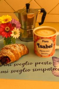 a cup of coffee and a croissant next to a cup of coffee at Sa Domittedda in Sassari
