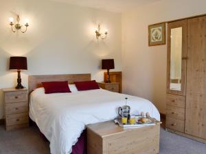 a bedroom with a large white bed with red pillows at Peace in Whauphill