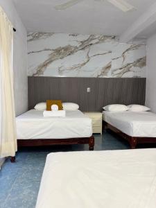 a bedroom with two beds with white sheets at Hotel Mirador--gratis bicicletas in Bacalar