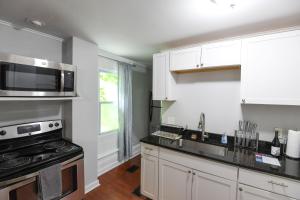 a kitchen with white cabinets and a stove top oven at Fully Remodeled, Charming Victorian Home in Rochester