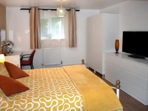 una camera da letto con un letto e una TV a schermo piatto di Fawns Cottage a Culmstock Altre 6 foto