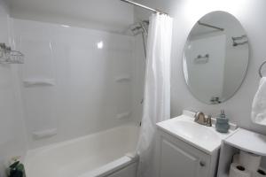a white bathroom with a sink and a mirror at Fully Remodeled, Charming Victorian Home in Rochester +24 photos
