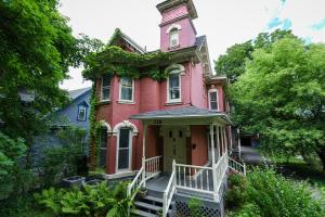 a pink house with a clock tower on top of it at Fully Remodeled, Charming Victorian Home in Rochester