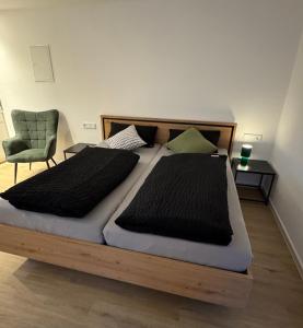 ein Schlafzimmer mit einem großen Bett und einem Stuhl in der Unterkunft Ferienwohnung Tee - Time - Lodge und Kirsch - Kiste in Momlingen