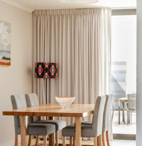 a dining room with a wooden table and chairs at Upscale neighbourhood guest quarters in Perth