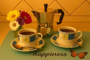 two cups of coffee sitting on a table with flowers at Sa Domittedda in Sassari +7 photos