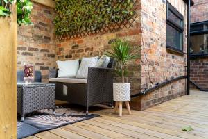 a patio with wicker chairs and a brick wall at O & A Retreat in York