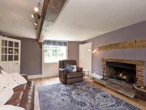 a living room with a chair and a fireplace at Cravens Manor in Sotherton