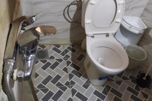 a bathroom with a toilet and a tile floor at Desert house in Merzouga