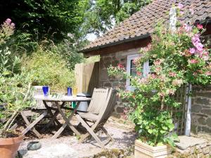 - une table et des chaises en face d'un cottage dans l'établissement Spring Cottage - Hw7734, à Tintern 2 autres photos
