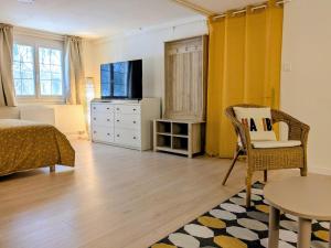 a bedroom with a bed and a table and a tv at Grande Suite Privée - Entrée indépendante - SDB & WC privatifs in Fondettes