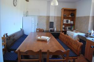 La cuisine est équipée d'une table et de chaises en bois ainsi que d'un réfrigérateur. dans l'établissement Los Polvazares, à Castrillo de los Polvazares