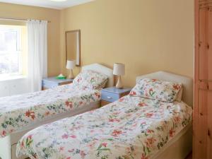 a bedroom with two beds and two lamps and a window at Oak Cottage-16498 in Catcleugh +6 photos