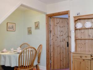 a dining room with a table and a wooden door at Amberley Cottage in Alfreton +7 photos