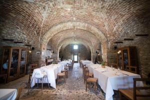 un restaurante con mesas y sillas blancas en un edificio de ladrillo en Masseria Salecchia, en Bovino