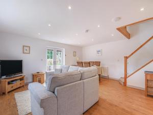 een woonkamer met een bank en een tv bij Annie's Cottage in Bempton