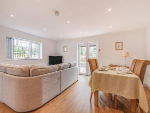 een woonkamer met een grote bank en een tafel bij Annie's Cottage in Bempton
