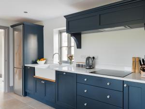 a kitchen with blue cabinets and a sink at The Foundary - Uk36319 in Whitchurch