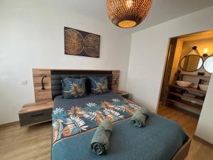 ein Schlafzimmer mit einem Bett mit einer blauen Bettdecke in der Unterkunft ARMONA in Brides-les-Bains