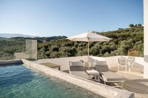 una piscina con due sedie e un ombrellone di Villa Life ad Agia Marina Nea Kydonias Altre 46 foto