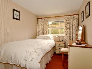 ein Schlafzimmer mit einem Bett und einem Fenster in der Unterkunft Molly's Cottage in Glenridding + 5 Fotos