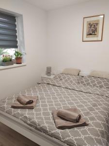 a large bed with two towels on top of it at Sobe i apartman Berecz in Kopačevo