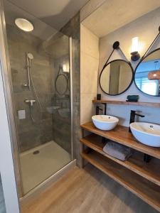 ein Badezimmer mit zwei Waschbecken und einer Dusche in der Unterkunft ARMONA in Brides-les-Bains