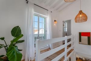 a white staircase in a room with a window at Brisa do Sul in Porches +26 photos