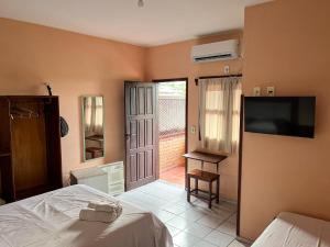 a bedroom with a bed and a flat screen tv at Bela Vista in Canoa Quebrada