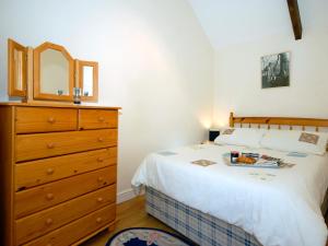 ein Schlafzimmer mit einem Bett mit einer Kommode und einem Spiegel in der Unterkunft Lower Bushford Cottage in Talbenny + 13 Fotos