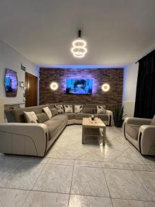 a living room with couches and a tv on a brick wall at Diamond Stay in Kilkís