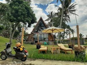 AmbaritaToba-A-Scape的一个人坐在房子前的踏板车上。