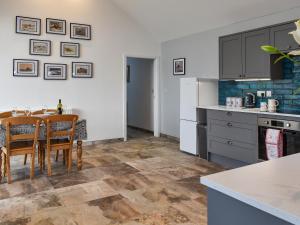 a kitchen with a table and chairs in a room at Branwen in Llanfachraeth