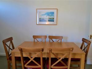 a wooden table with four chairs and a picture on the wall at Tarquins in Fowey