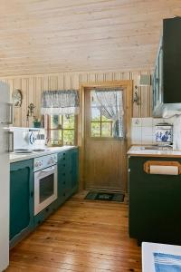une cuisine avec des placards verts et un sol en bois dans l'établissement Traditional Cabin By Reinsvatn In Treungen, à Treungen 23 autres photos