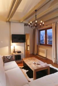 een woonkamer met een witte bank en een tafel bij Lemon Apartments in Krynica Zdrój